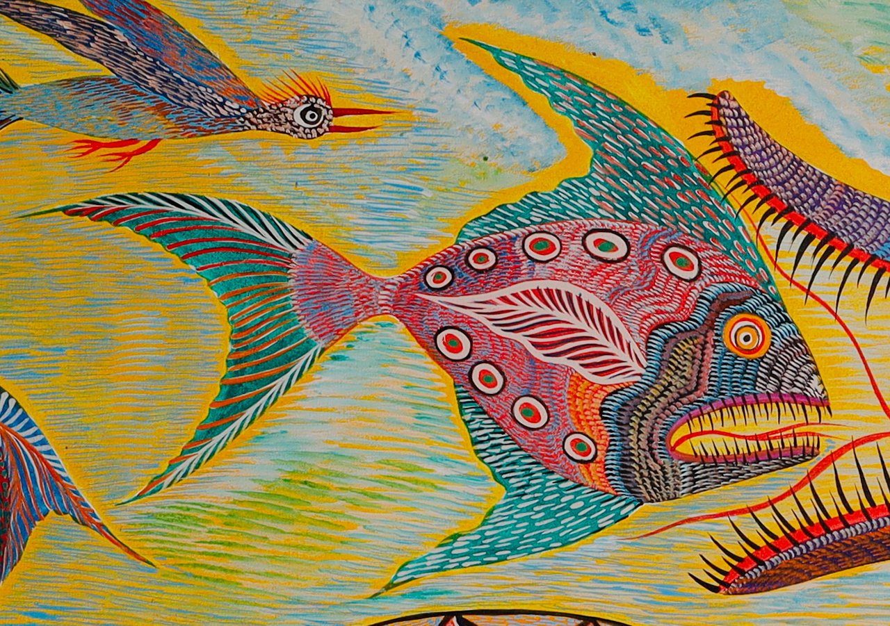 Pink fish with green spots and fins, its mouth open in front of the snake's head. Detail of Fish Birds and Snake, Chico da Silva by Babá, 2006.