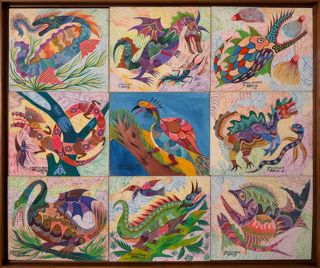 Nove pinturas pequenas numa caixa de madeira: dragões, serpentes marinhas, peixes fantásticos e uma ave de crista sobre fundo azul. Animais Fantásticos, Chico da Silva por Garcia, 2005–2006, acrílica sobre tela.